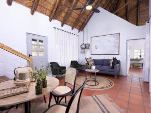 提姆巴瓦提禁猎区Simbavati Mvubu Cottage的客厅配有蓝色的沙发和桌椅