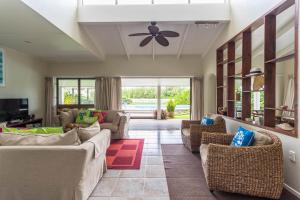 拉罗汤加穆里海滩别墅的带沙发和吊扇的客厅