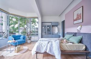 胡志明市M Village Lý Chính Thắng的一间卧室配有一张床和一张蓝色的沙发