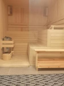 ProgledGORA уютна планинска къща до ски зона Пампорово的客房设有带木地板和桌子的桑拿浴室。