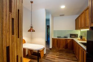 金塔马尼Tira Vilagna Suites & Spa的厨房配有木制橱柜和桌子