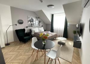 塔塔Dotis Apartman Tata的卧室配有一张床和一张桌子及椅子