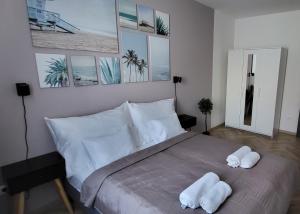 塔塔Dotis Apartman Tata的一间卧室配有一张床,上面有两条毛巾