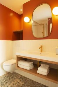 巴黎巴蒂诺勒酒店的一间带水槽、卫生间和镜子的浴室