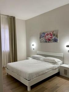 BruscianoHotel Villa Ruggiero的白色卧室配有一张床,墙上挂着一幅画