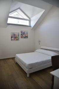BruscianoHotel Villa Ruggiero的白色的客房设有两张床和窗户。