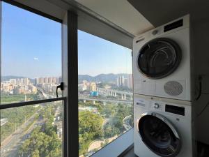 深圳深圳时尚LOFT公寓的带窗户的客房内的洗衣机