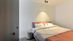 克诺克－海斯特Orfeo Knokke的一间卧室配有一张带橙色毯子的床