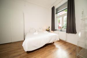 杜塞尔多夫WHITE 60 QM Apartment - Zentral - Balkon - Messe的白色的卧室设有白色的床和窗户。