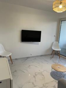 普罗旺斯艾克斯Superbe appartement avec balcon et parking的客厅的墙上配有平面电视。