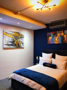 开普敦Queen Julie Lodge的一间卧室配有一张带蓝色墙壁的大床