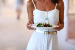 帕尔马海滩Iberostar Selection Playa de Palma的穿着白色衣服,拿着一盘食物的妇女