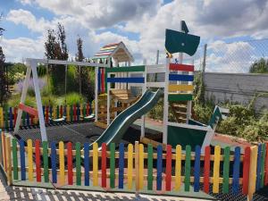 热舒夫Garden Zajazd的一个带滑梯和五颜六色围栏的游乐场