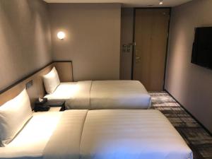 台北德立庄酒店的酒店客房设有两张床和电视。