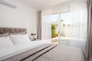 阿尔库迪亚港VILLA CLAUDINE的白色卧室设有床和滑动玻璃门
