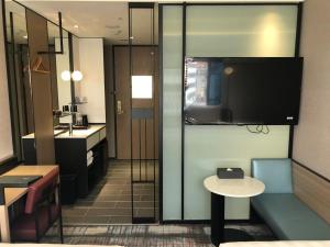台北德立庄酒店的一间带电视、桌子和水槽的浴室