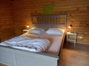 Bertognele sanglier的木房内的一张大床,配有两盏灯