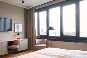慕尼黑Scandic München Macherei的酒店客房设有一张床、一张书桌和窗户。