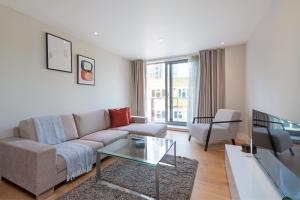 伦敦Stayo Apartments Southbank的带沙发和玻璃桌的客厅