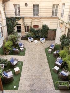 波尔多L'Apparthôtel Particulier Bordeaux的一座带桌椅的户外庭院和一座建筑