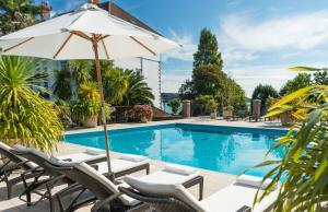 圣布雷拉德圣布雷拉德湾酒店的一个带躺椅和遮阳伞的游泳池
