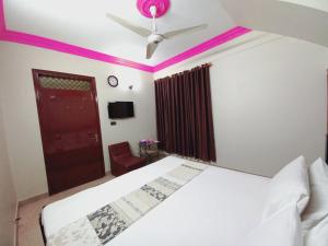 卡拉奇Gulshan Family Guest House Near Millennium Mall的卧室配有白色的床和吊扇