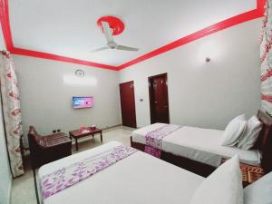 卡拉奇Gulshan Family Guest House Near Millennium Mall的酒店客房配有两张床和吊扇。