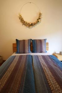 卢加诺Casa Holamundo - romantisches Tessiner Steinhaus (vegi)的卧室配有一张带花圈的床铺,墙上挂有花圈