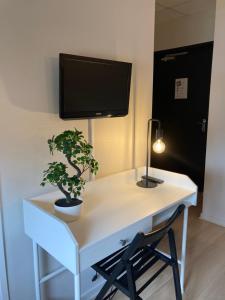 AnglefortLE HAYLTON的一张带电视及植物的白色书桌