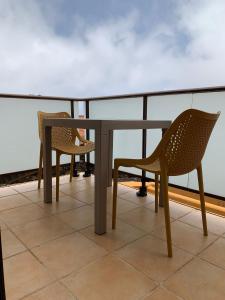 巴尔韦尔德Apartamentos Los Catorce, EL Hierro的阳台配有2把椅子和1张桌子