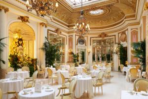 伦敦伦敦丽兹酒店的餐厅配有白色的桌椅和吊灯