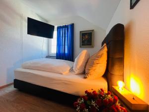 HinwilHotel Hirschen Hinwil的一间卧室配有一张带蓝色窗帘的床和窗户