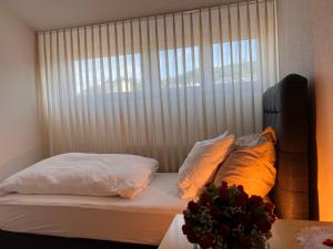 HinwilHotel Hirschen Hinwil的卧室配有带枕头的床铺和窗户。