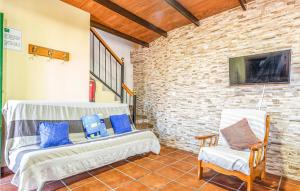 卡萨拉博内拉Amazing Home In Casarabonela With Kitchenette的客厅配有两把白色椅子和砖墙