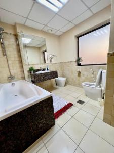迪拜York Backpackers - Jumeirah Beach的带浴缸和卫生间的大型浴室