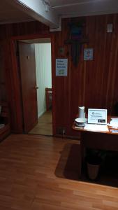 比亚里卡Hostal Valentino Villarrica的客房设有书桌、门和桌子。