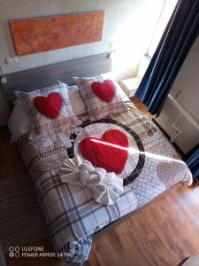 MaissanaNew Arcobaleno Ossegna的一张带心枕的床和一条带心的毯子