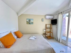 维琪奥港蓝色故事公寓酒店的一间卧室配有带橙色枕头的床和窗户。