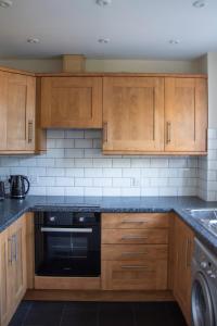 科尔切斯特Lovely 3-bedroom apartment in Colchester的厨房配有木制橱柜和黑色洗碗机。