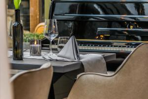 滨湖新锡德尔达斯斯塔德豪斯酒店的一张桌子,上面放着一杯葡萄酒和一架钢琴
