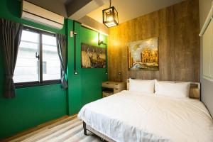 成功镇一蓑烟雨的一间卧室设有一张床和绿色的墙壁