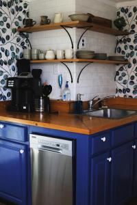 詹姆斯敦Sweet Mary home的厨房配有蓝色橱柜和不锈钢洗碗机。