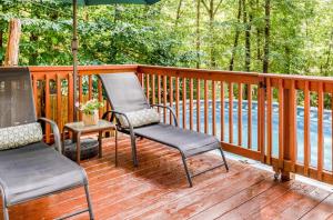 东斯特劳兹堡Pocono cabin with private pool at Shawnee Mtn的甲板上配有两把椅子和一把遮阳伞