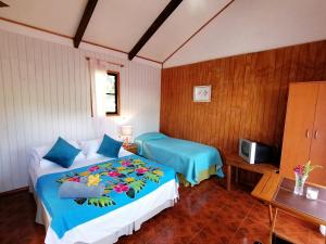 安加罗阿Tuava Lodge的一间卧室配有两张床和电视。