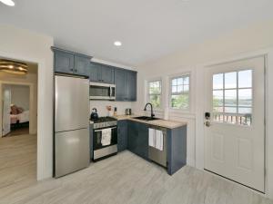纽堡Deck View of Hudson River & Mt Beacon / Boho Suite的厨房配有蓝色橱柜和冰箱。