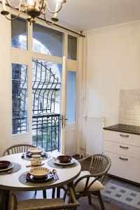 布达佩斯Adorable, cosy apartment at the Heroes' Square Budapest的一间带桌椅和窗户的用餐室