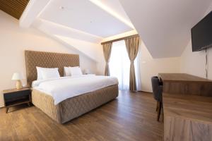 普里兹伦Hotel Castello的一间卧室设有一张床、一台电视和一个窗口。