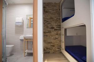 卢戈Hostel Cross的浴室设有卧室,墙上配有电视。