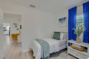 波因顿海滩Boynton Beach Getaway的白色卧室配有蓝色窗帘的床