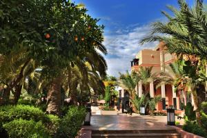 马拉喀什马拉喀什莫凡彼酒店的棕榈树庭院和建筑